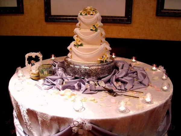 Свадебный торт на столе в окружении свечей