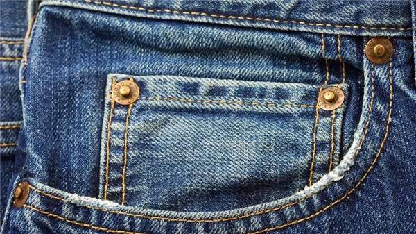 Карман с заклепками на синих джинсах