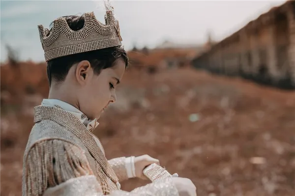 Мальчик в короне играет на пустыре
