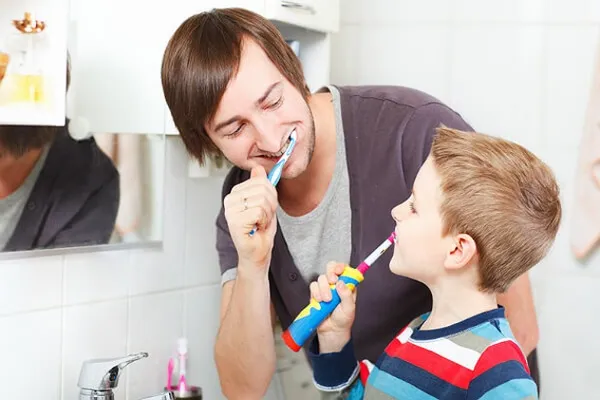 Ребенок чистит зубы электрической щеткой