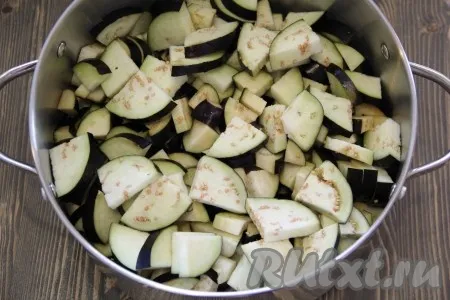 Баклажаны вымыть, срезать хвостики и нарезать средними кусочками. Выложить баклажаны в большую кастрюлю. Я использовала кастрюлю объёмом 7 литров.